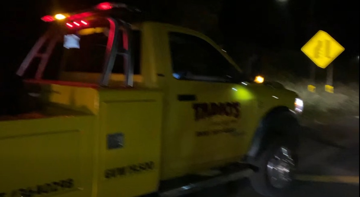 Tow truck providing roadside assistance at night